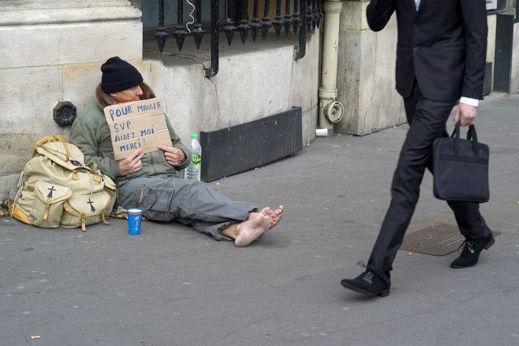 乞討者手舉紙牌上寫著：「要吃東西，請幫助我，謝謝！」